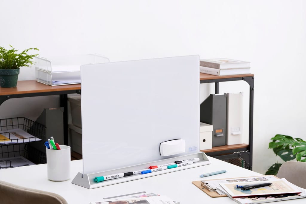 辦公桌上簡潔的玻璃白板，搭配整齊辦公用品與綠植，展現專業辦公氛圍。