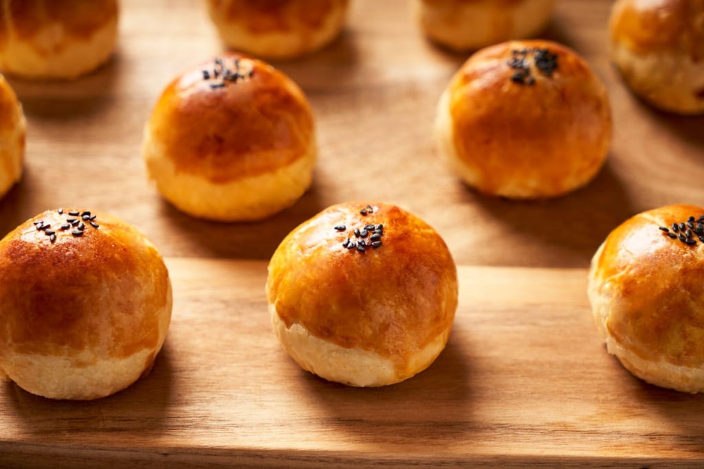 鮮味珍食品舖金黃酥皮糕餅在木質背景上，展現企業真誠的美味樣貌。