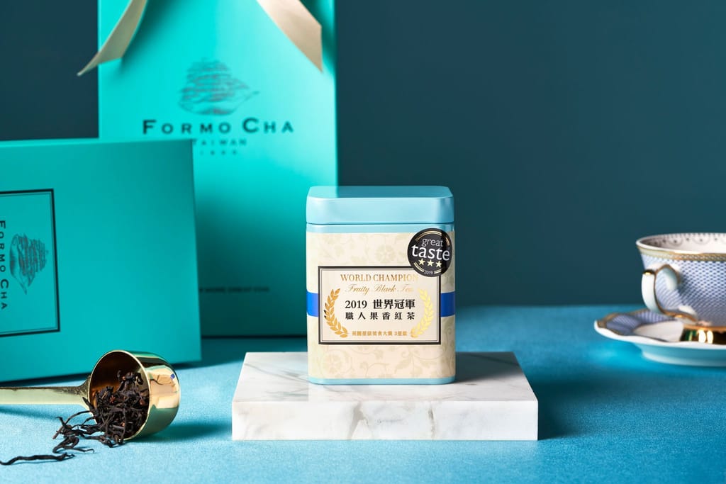 福爾摩茶世界冠軍紅茶禮盒情境，展示藍綠色包裝、茶罐、茶杯與茶葉。