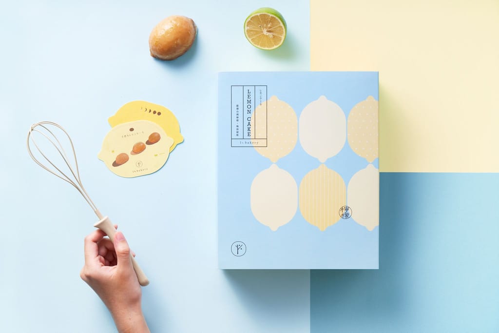 1%bakery 2019中秋檸檬蛋糕禮盒情境照，以淺藍黃色調搭配手持打蛋器與檸檬，營造清爽節慶感。