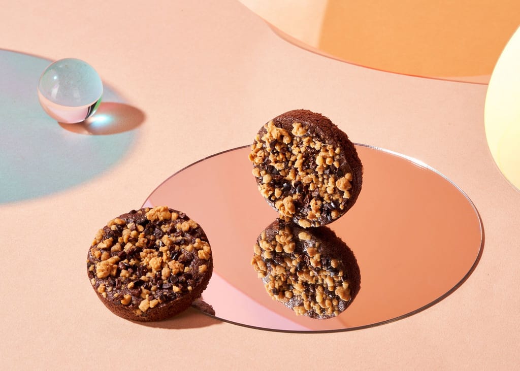 布列塔尼風味點心，深色餅體覆酥脆碎粒，玫瑰金鏡面呈現精緻質感。