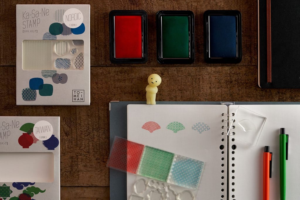 質感系文具展示，桌面擺放印章組、印泥與筆記本等文具。