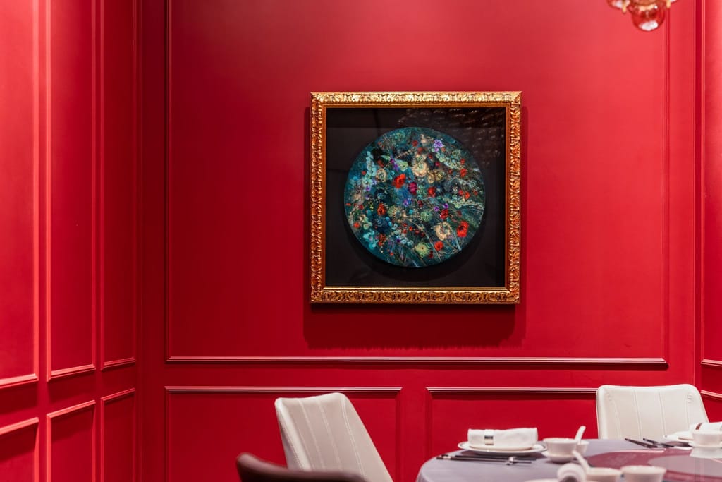 頂粵吉品餐廳紅色包廂，牆面藝術畫作與典雅餐桌，展現精緻空間美學。