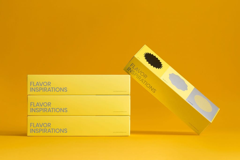 Three stacked yellow "FLAVOR INSPIRATIONS" product boxes and one tilted box, all against a bright yellow background.