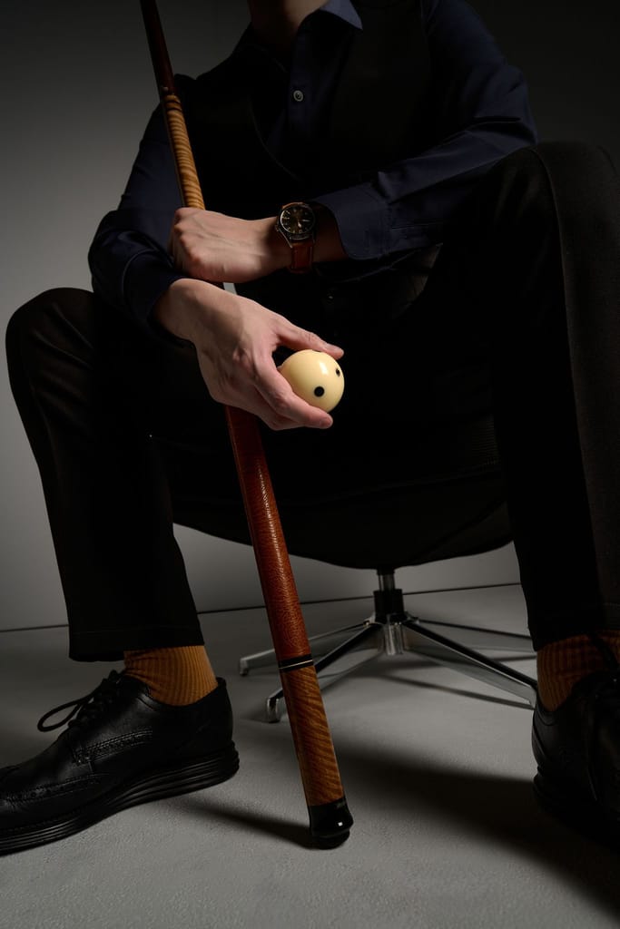 身著正裝的選手手握撞球桿與球，呈現專業沉穩的企業代表形象。