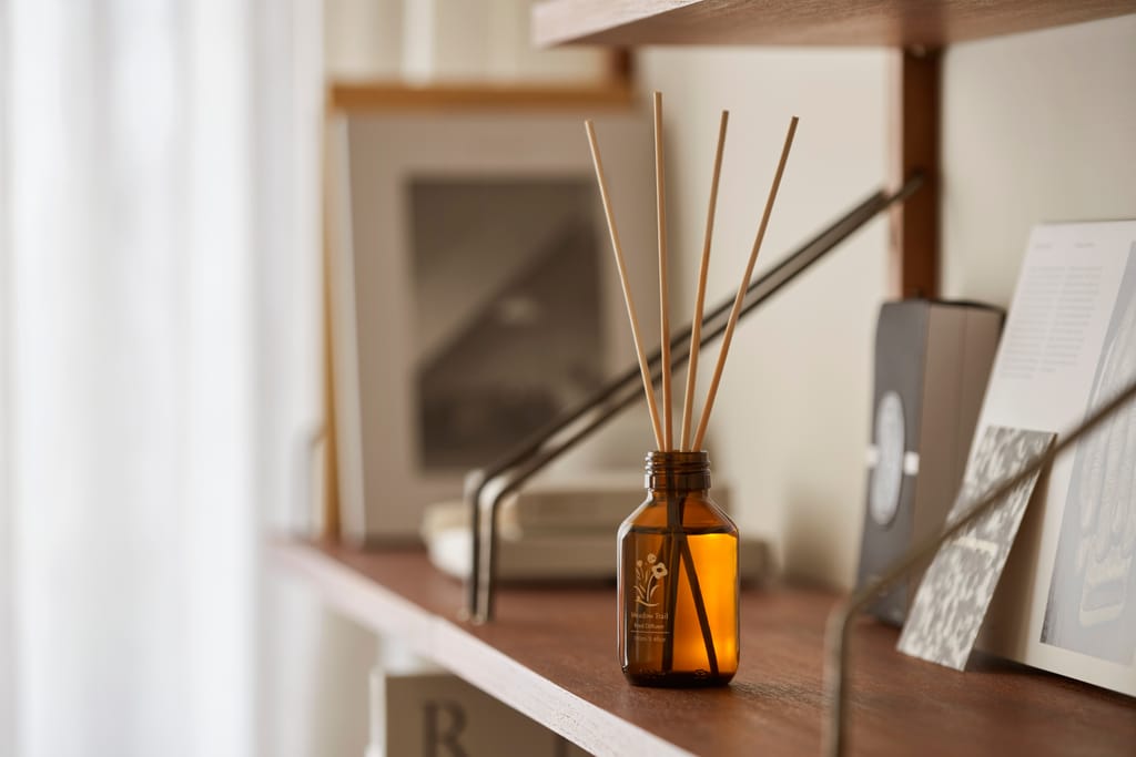 木質層架上，一瓶擴香瓶散發著溫潤的天然香氣，營造居家舒適氛圍。