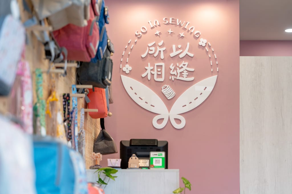 門市內以粉色牆面烘托「所以相縫」品牌標誌，展現溫暖迎新生命的主題。