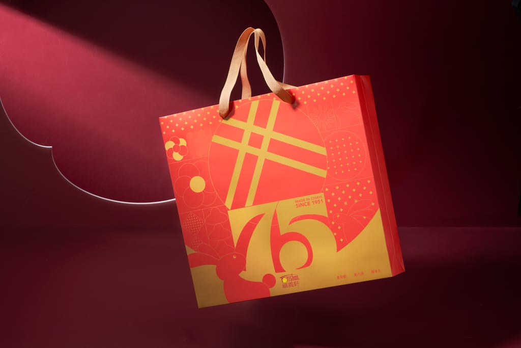 以喜慶紅金呈現的75週年紀念禮盒提袋，象徵經典傳承。