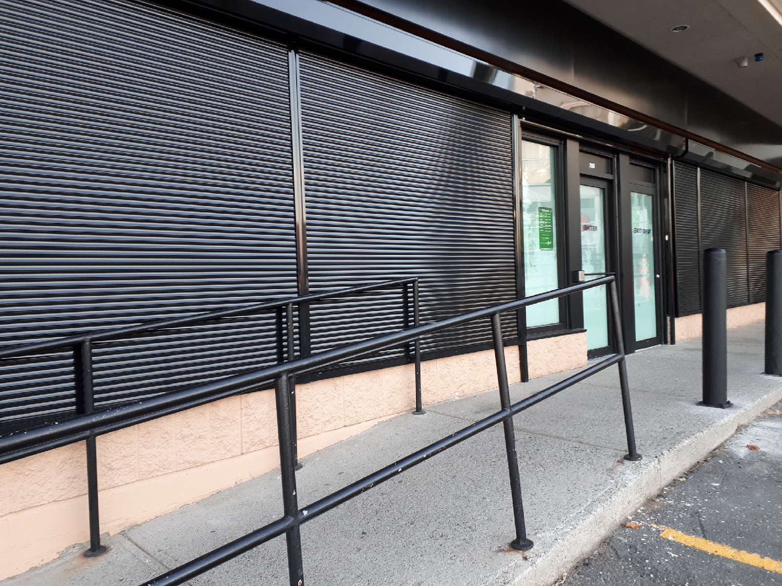 Entrance to store with black security rollshutters