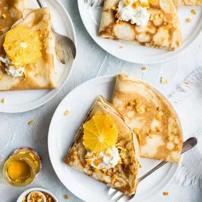 des crêpes sur une assiette avec quelques framboises