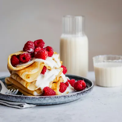 crêpes des crêpes sur une assiette avec quelques framboises