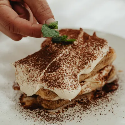une part de tiramisu sur une assiette blanche