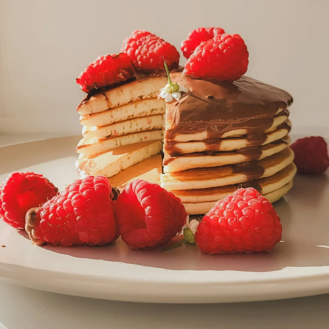 Une pile de pancakes sur lequel on verse du sirop d'érable
