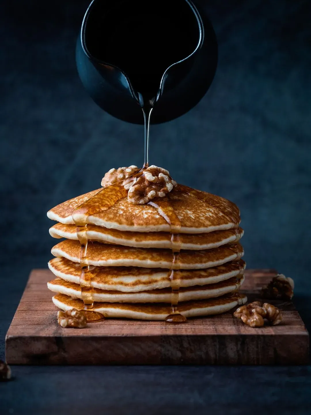 Une pile de pancakes sur lequel on verse du sirop d'érable 