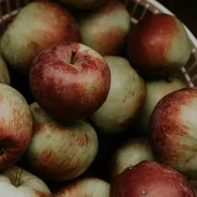 des pommes sur une planche en bois avec un couteau