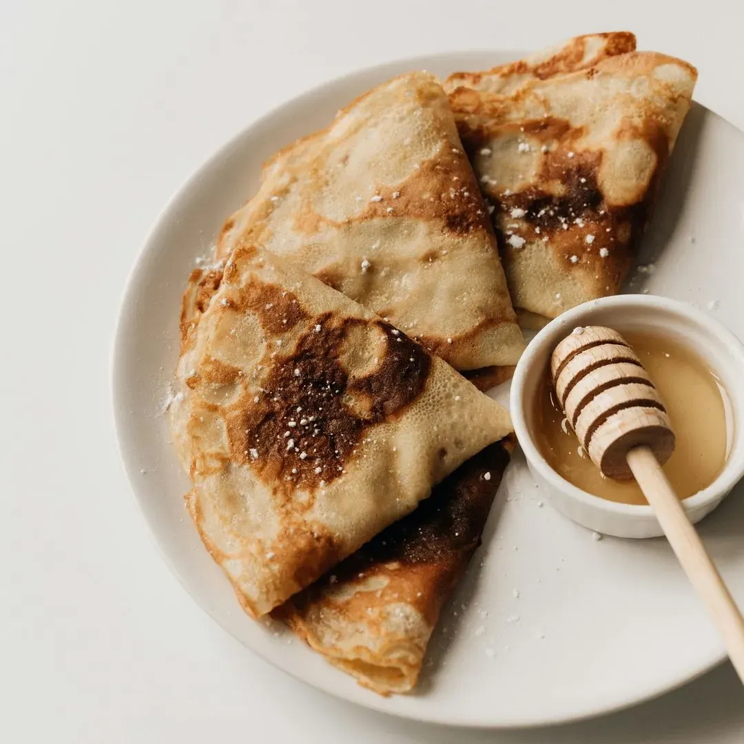 une crêpe en train de cuire sur une poêle en fonte