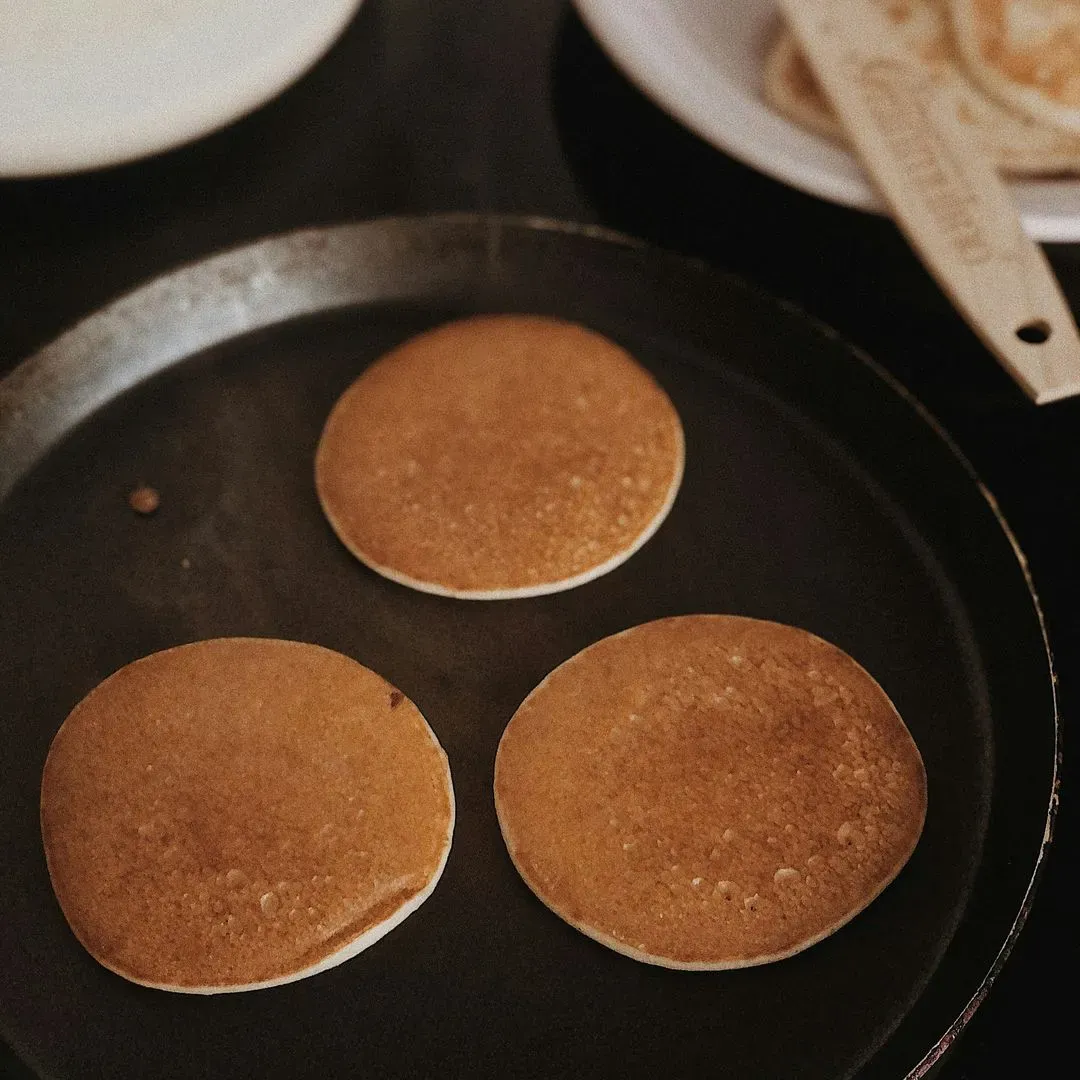 des pancakes ronds en train de cuire dans une poele