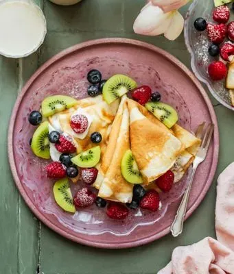 des crêpes garnies de fruit sur une assiette