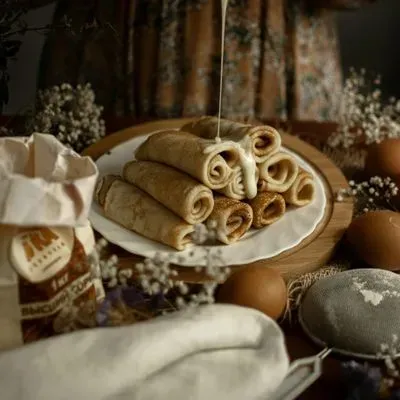 des crêpes roulées sur une assiette sur une table décorée