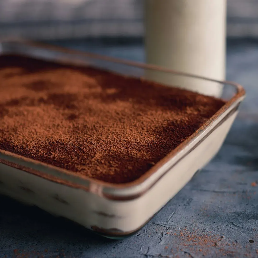 un tiramisu dans un plat avec une part en moins