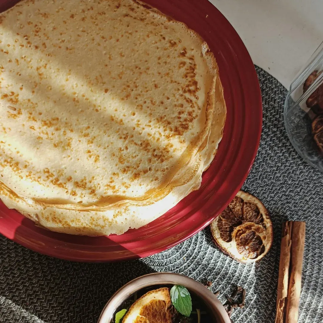 des crêpes sur une assiette avec des fruits séchés sur un plan de travail