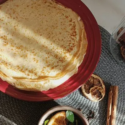 des crêpes sur une assiette avec des fruits séchés sur un plan de travail