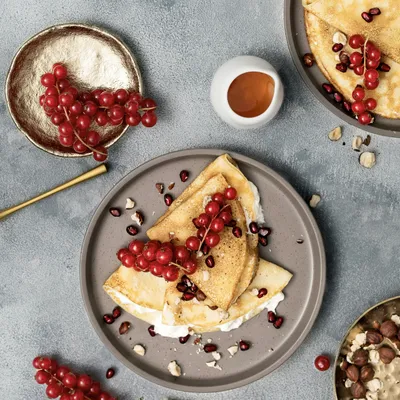 des crêpes sur une assiette avec des fruits séchés sur un plan de travail