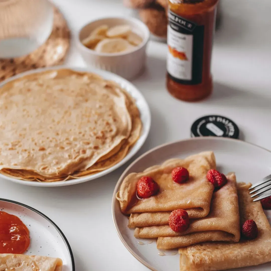 une table garnie de crêpes et de confiture