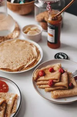 une table garnie de crêpes et de confiture
