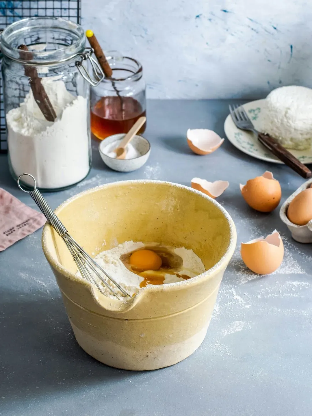 un bol avec les ingrédients pour faire des crêpes sur un plan de travail