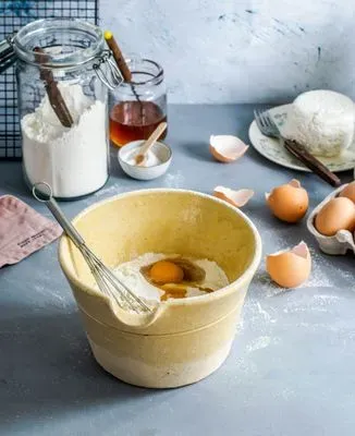 un bol avec les ingrédients pour faire des crêpes sur un plan de travail