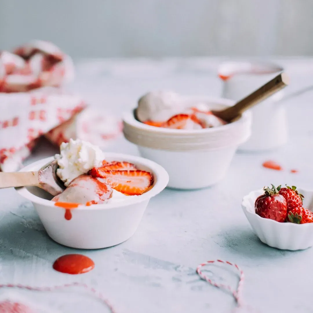 4 fraises congelées sur un plan de travail blanc