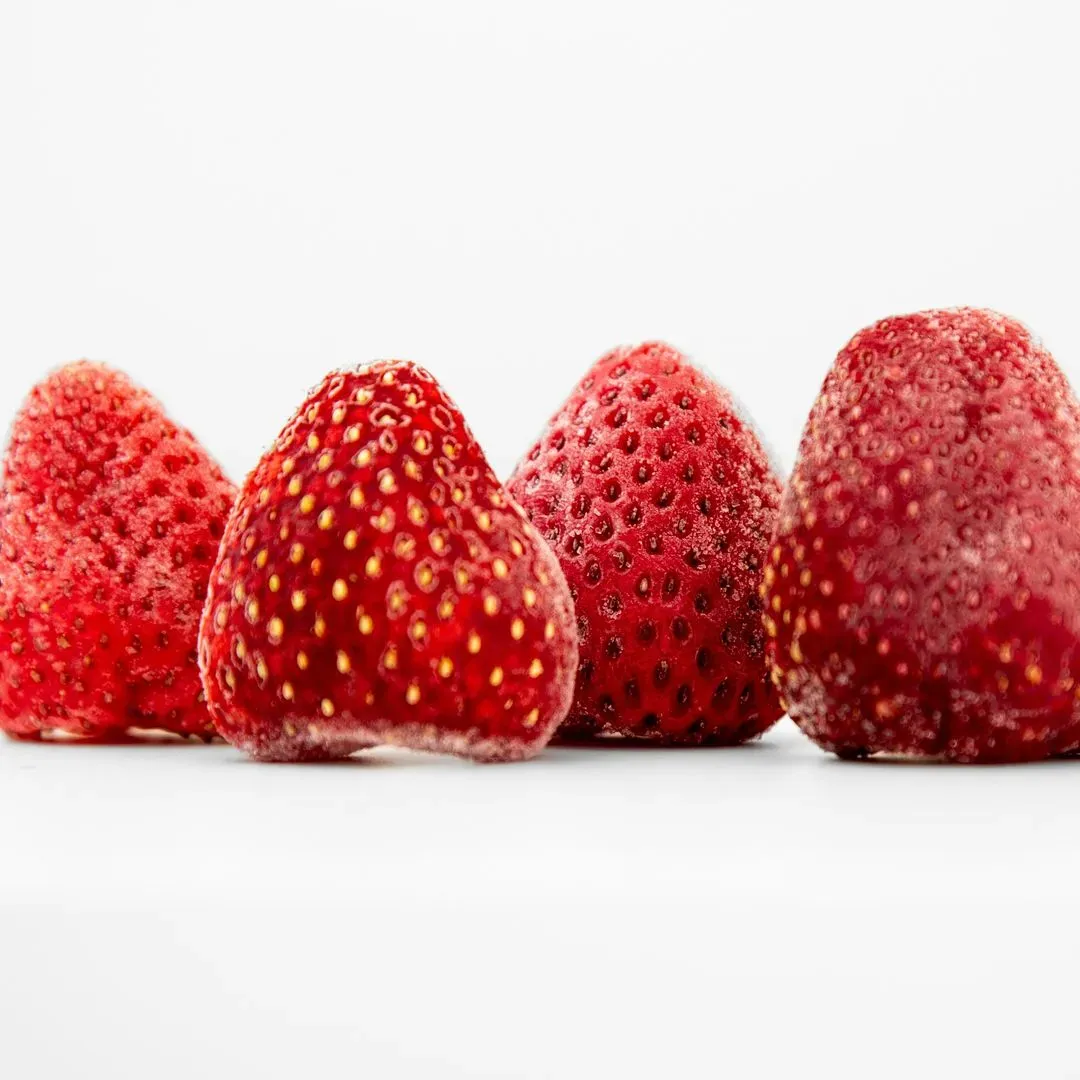 4 fraises congelées sur un plan de travail blanc