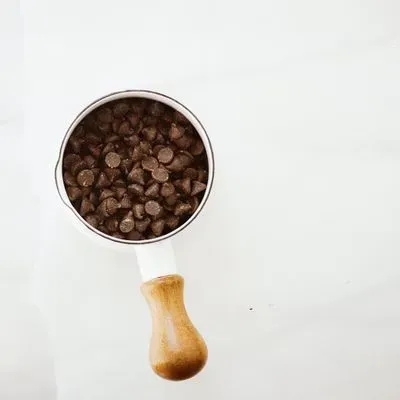 Des pépites de chocolat dans un bol sur une surface blanche