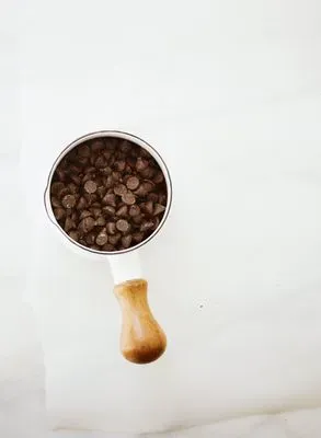 Des pépites de chocolat dans un bol sur une surface blanche