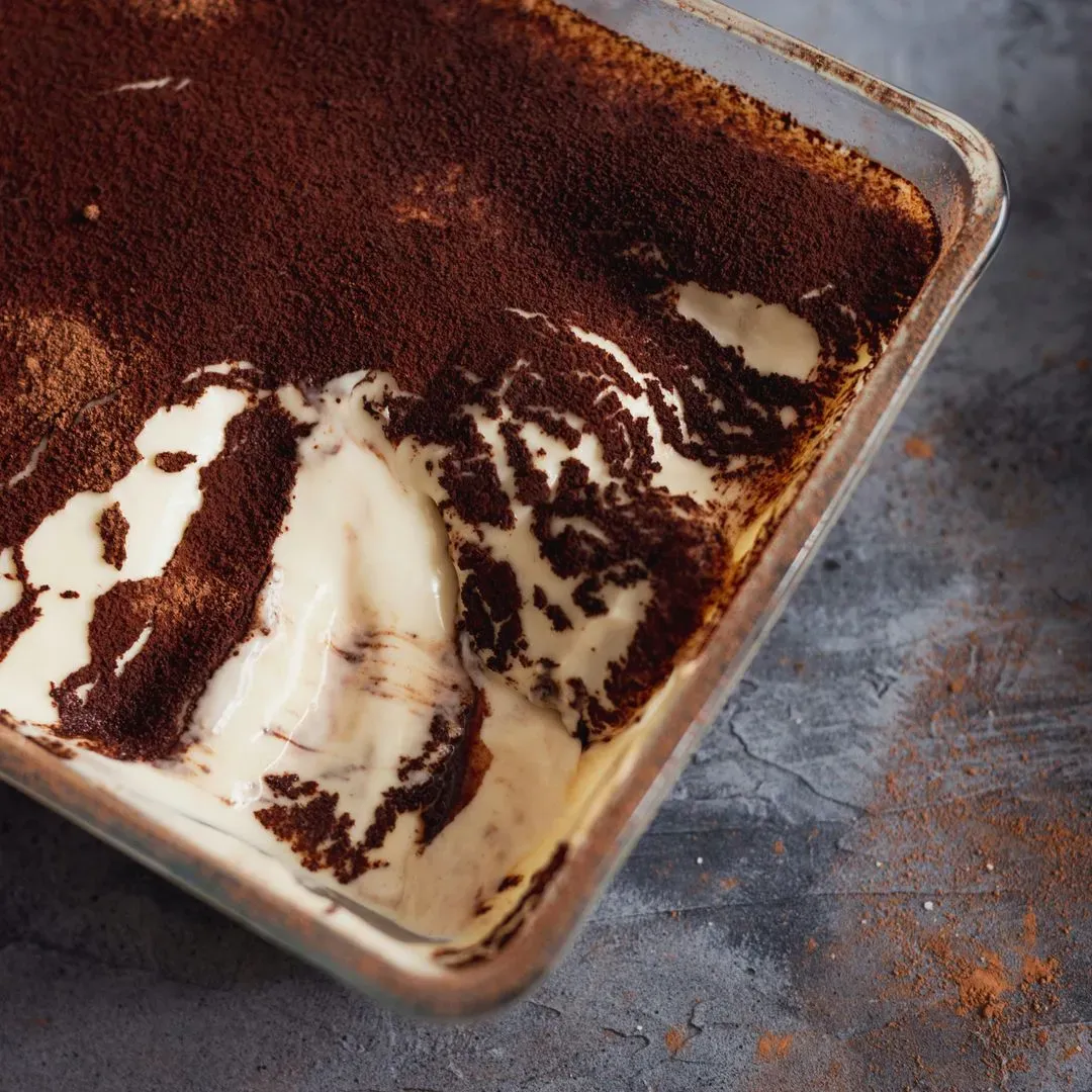 une tiramisu saupoudré de cacao dans un plat