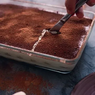 une tiramisu saupoudré de cacao dans un plat