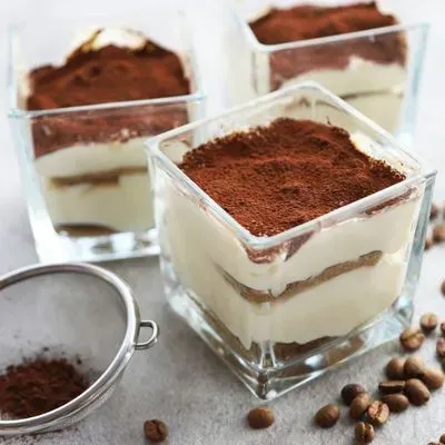 des tiramisu en verrines saupoudrés de cacao 