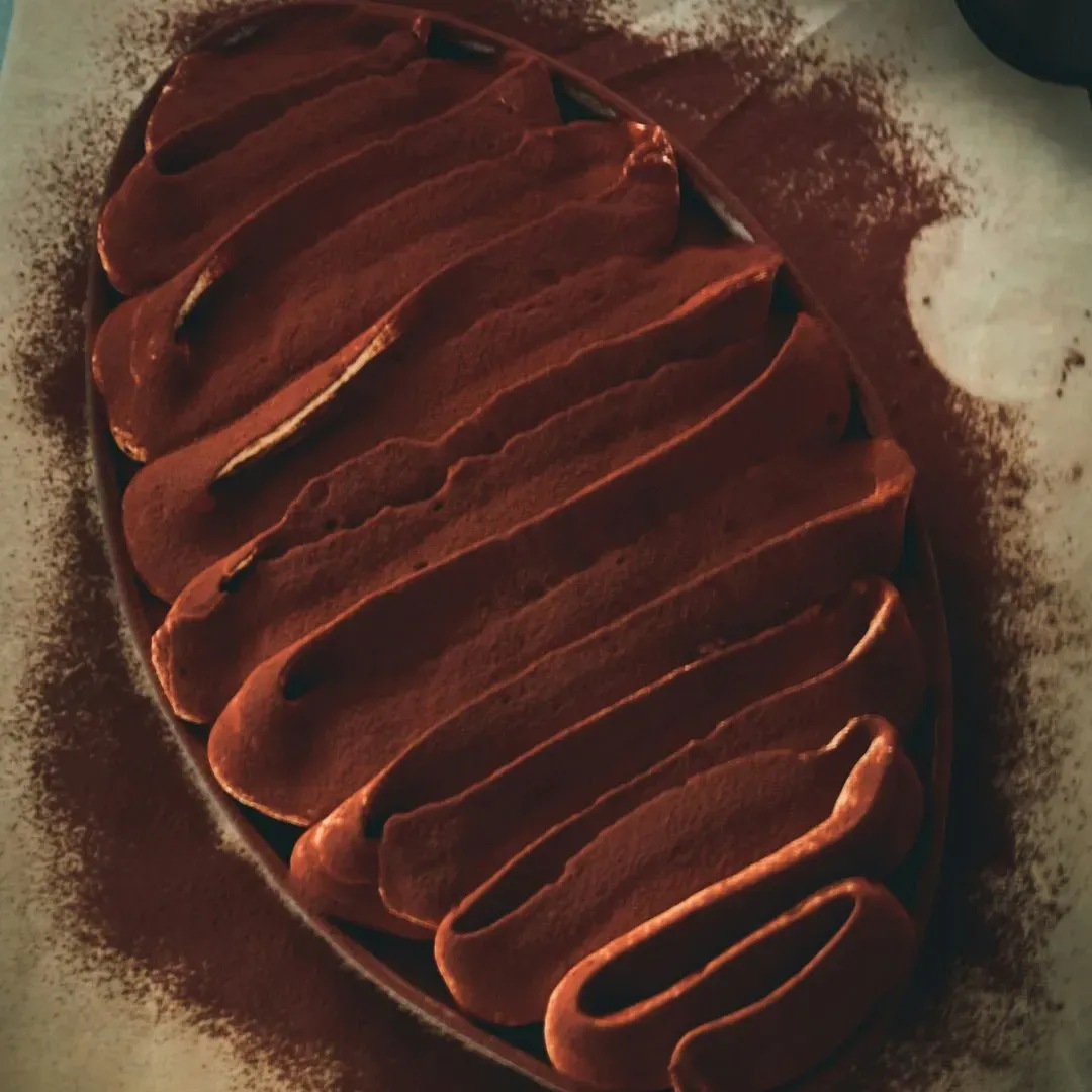 un tiramisu dans un moule à gratin blanc