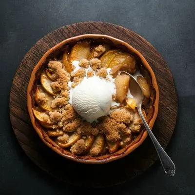 un crumble aux pommes avec une boule de glace à la vanille au milieu