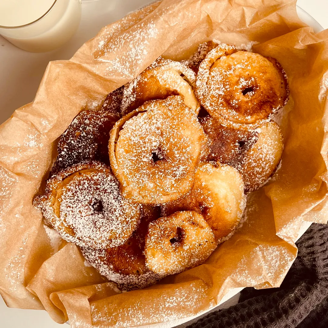 des beignets aux pommes saupoudrés de sucre glace