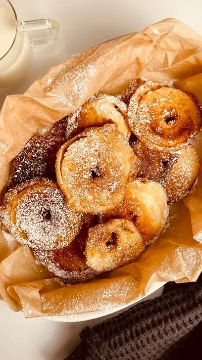 des beignets aux pommes saupoudrés de sucre glace