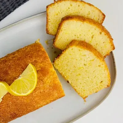 un cake au citron sur un plat avec  parts découpées