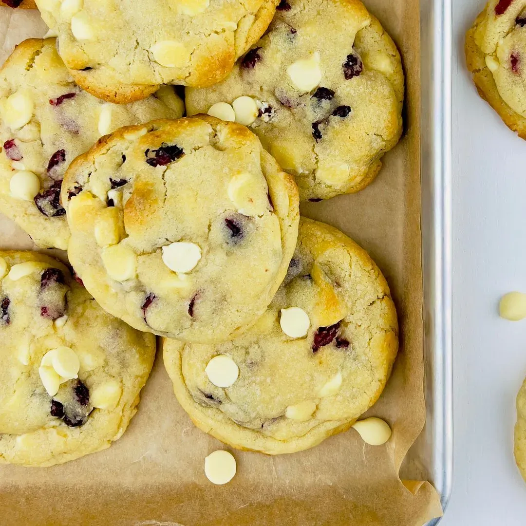 des cookies au chocolat blanc et cranberries sur une plaque de cuisson 