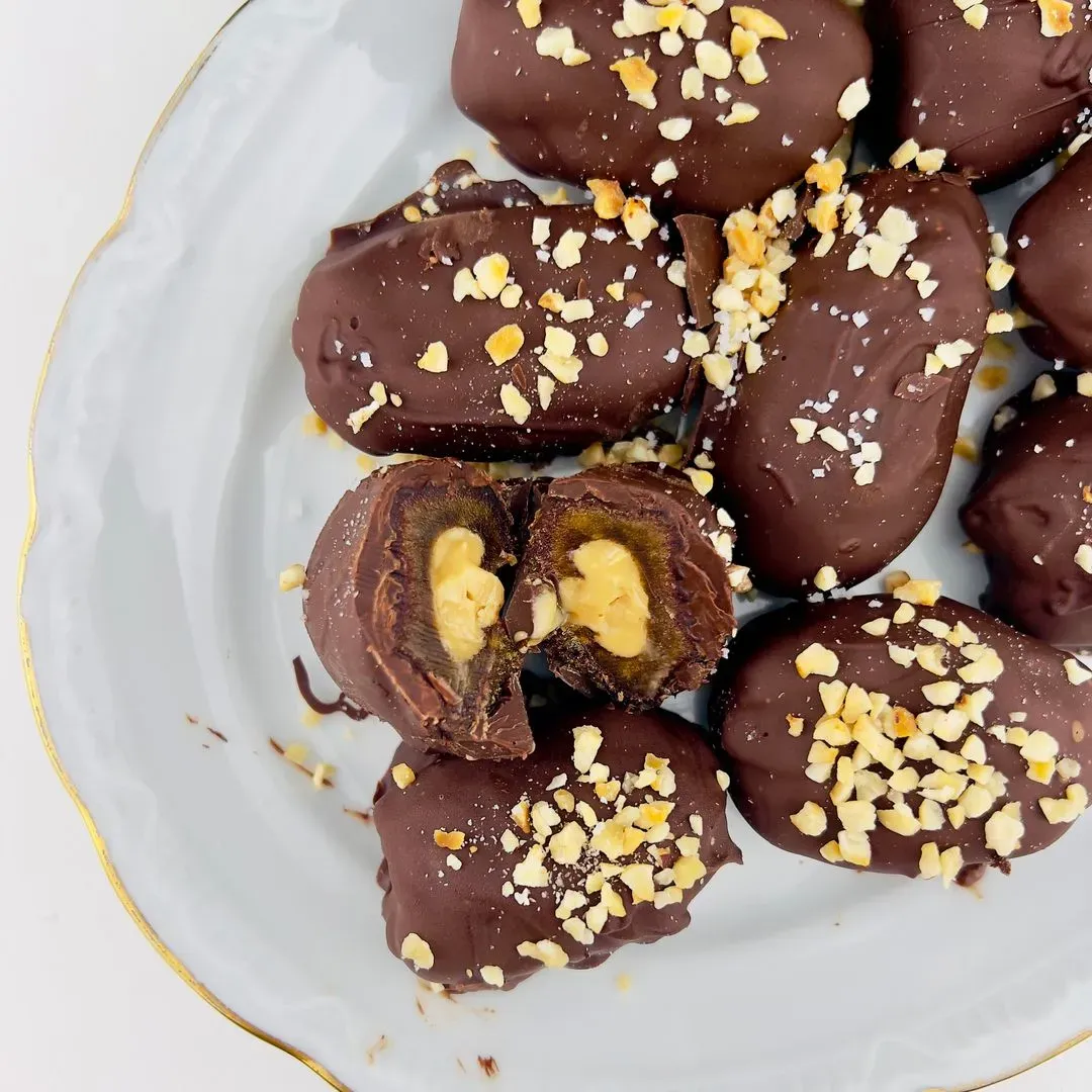 des dattes enrobées de chocolat sur une assiette