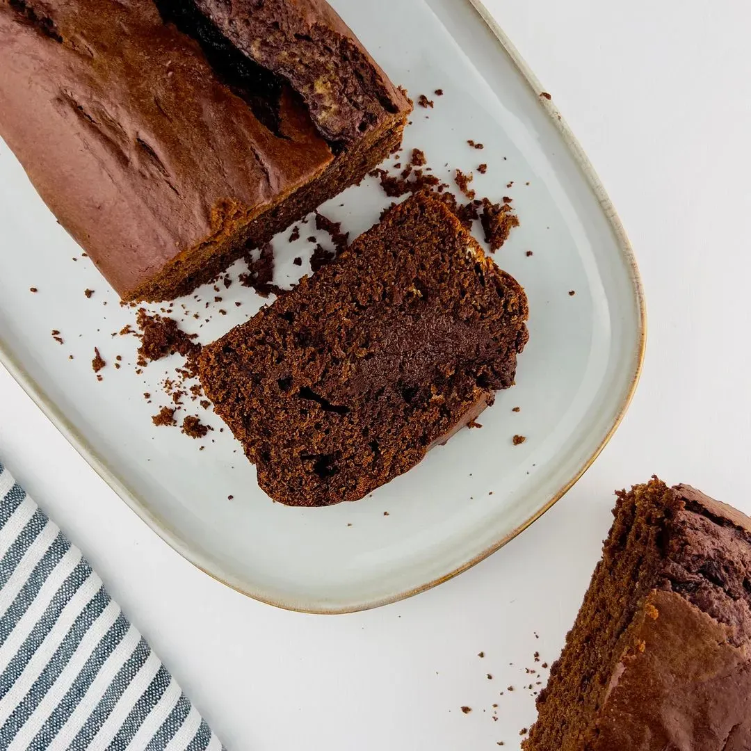 un gateau yaourt chocolat sur un plat et la première part coupée