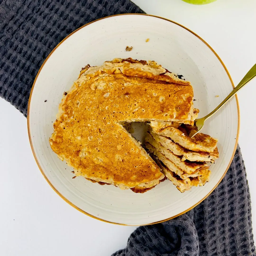 des pancakes aux pommes coupés sur une assiette