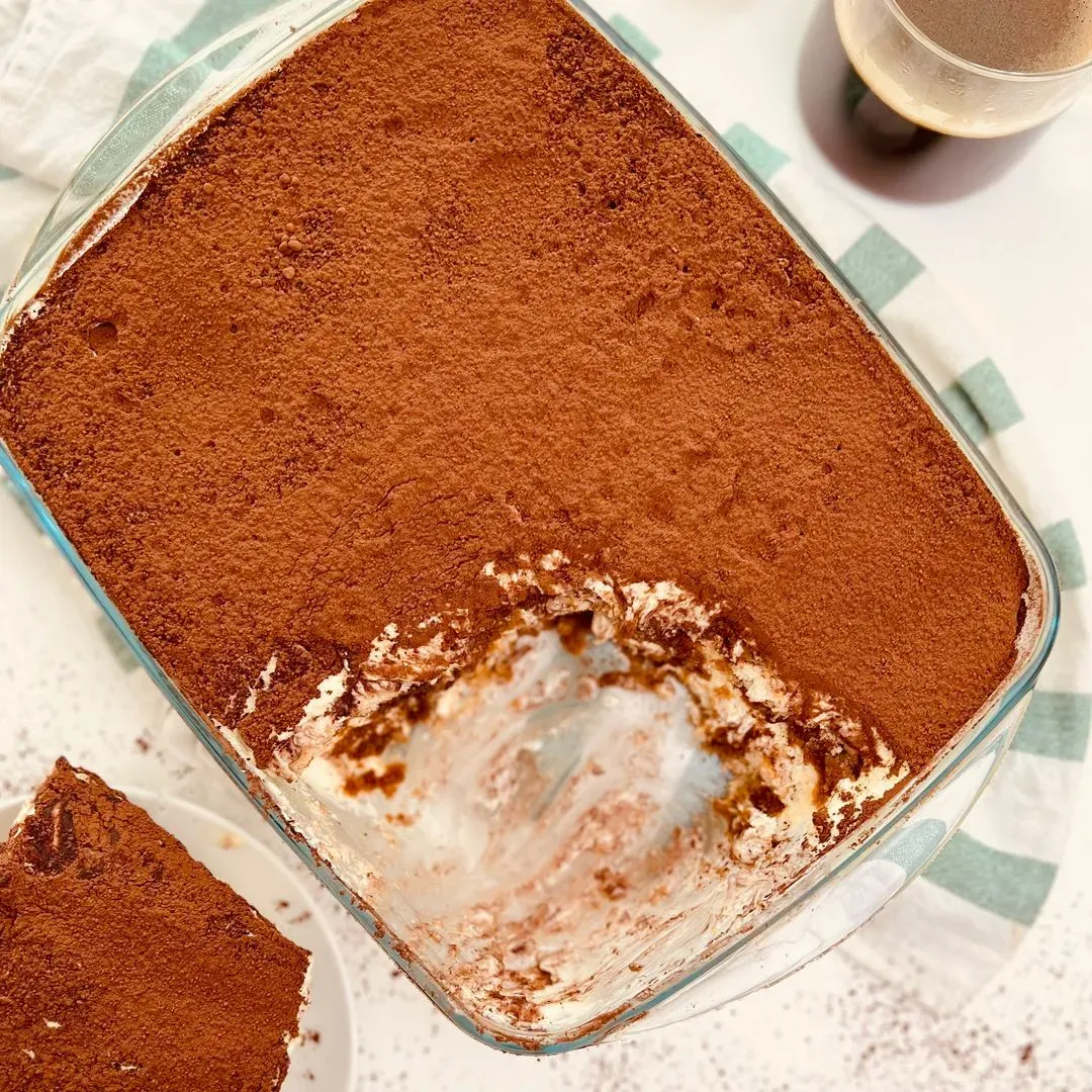 Un plat avec un morceau de tiramisu  une tasse de café