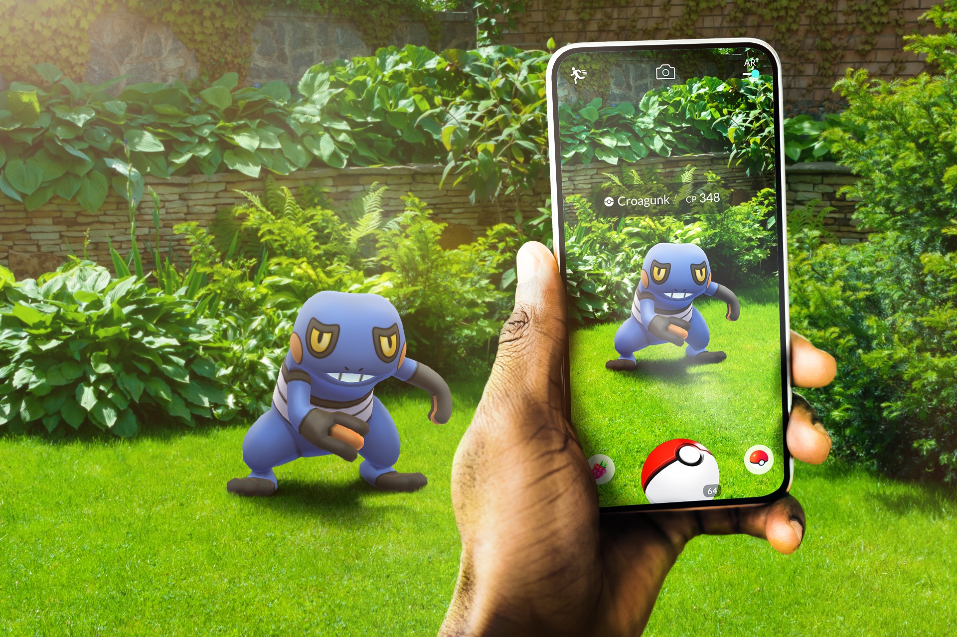 Pokémon GO: a hand holding a phone that shows Croagunk in augmented reality on a garden lawn