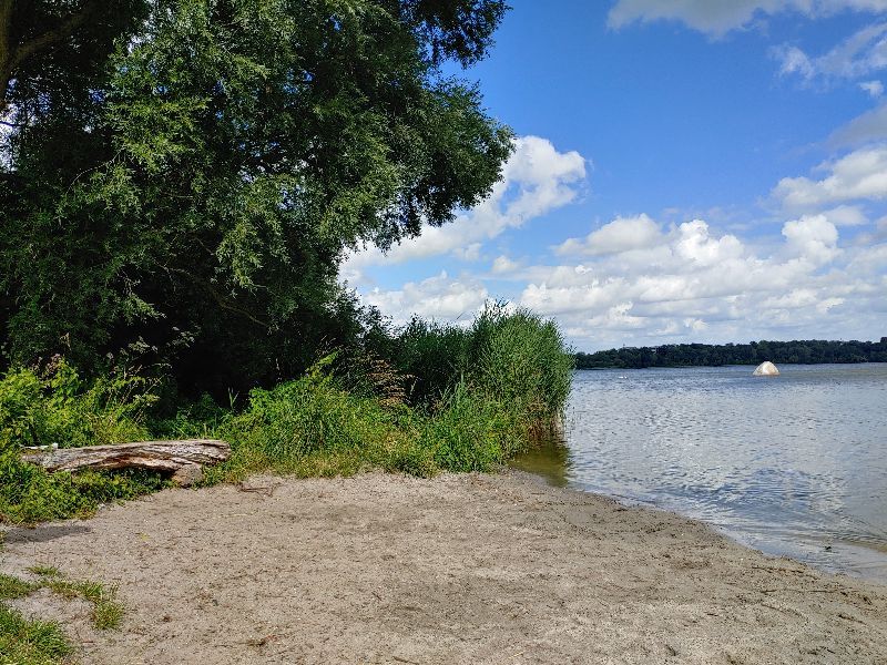 Hidden beach with bench and view over the Noor and the findling rock